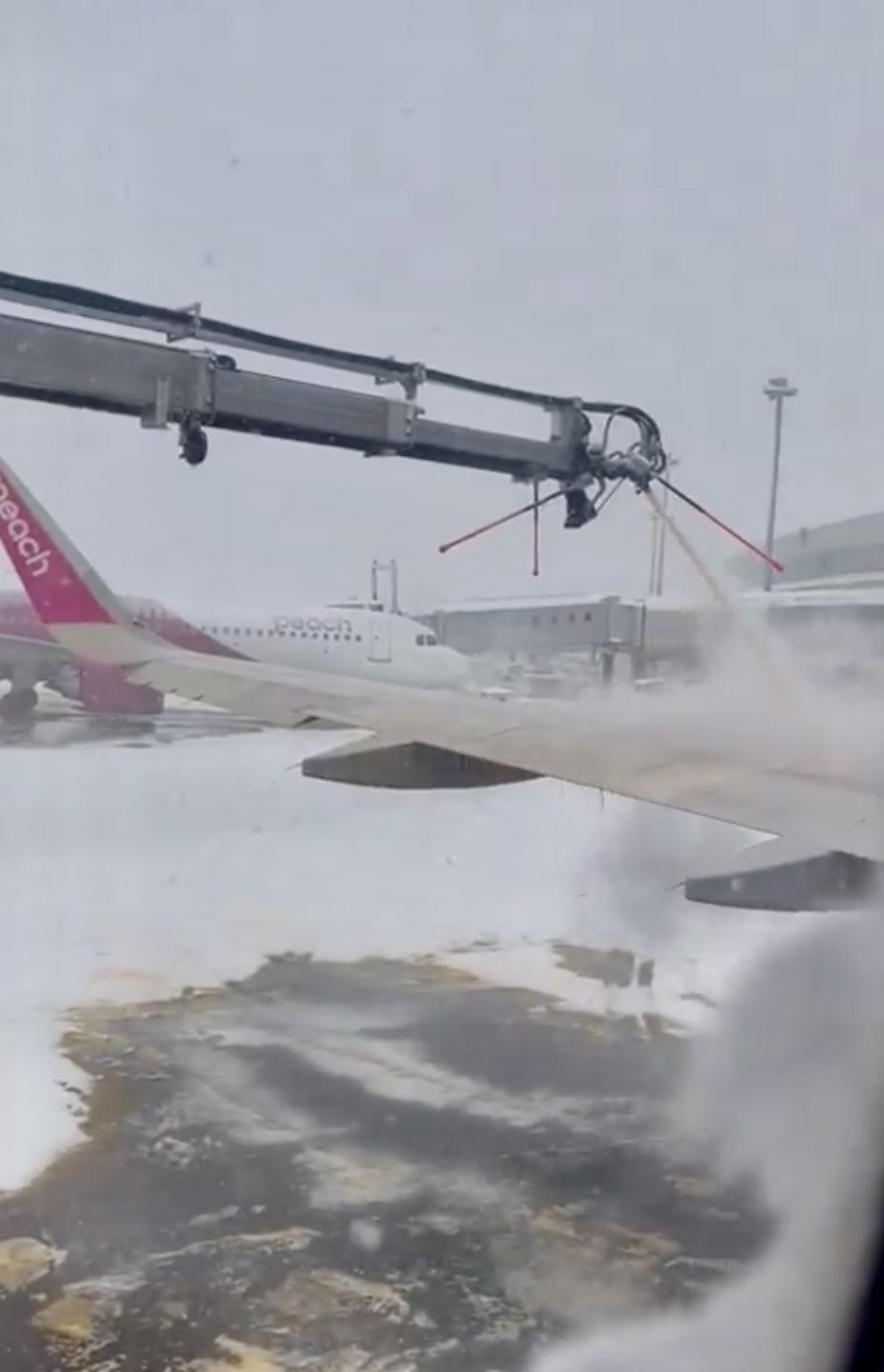 乘客在机内看机翼喷除雪剂。 X
