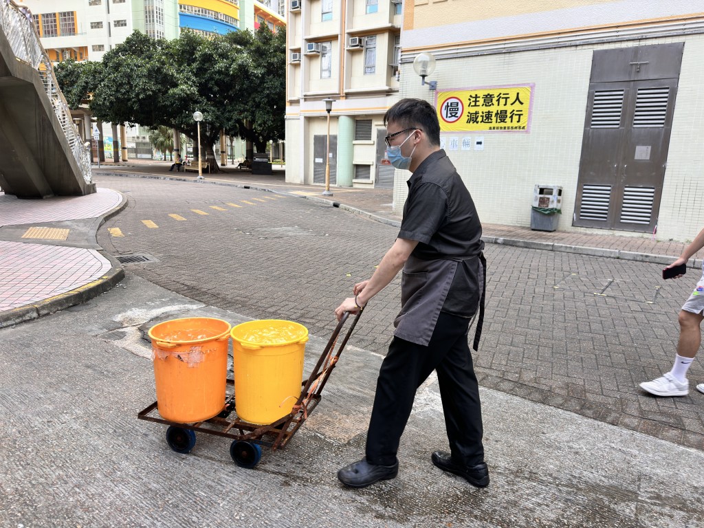 餐廳員工到水車載水。