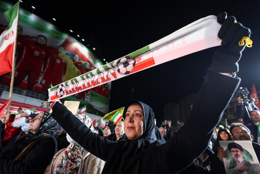 民众举起横额欢迎女足归国。路透社