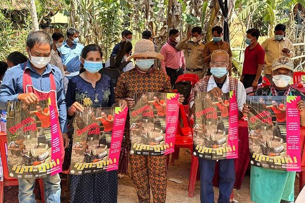 柬埔寨民眾手持預防禽流感宣傳畫。