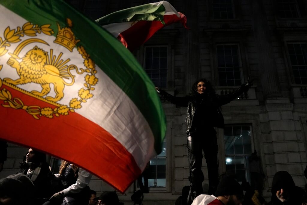 倫敦民眾聚集在首相官邸外聲援伊朗人民,揮舞1979年伊朗革命前舊國旗。法新社 倫敦民眾聚集在首相官邸外聲援伊朗人民,揮舞1979年伊朗革命前舊國旗。法新社