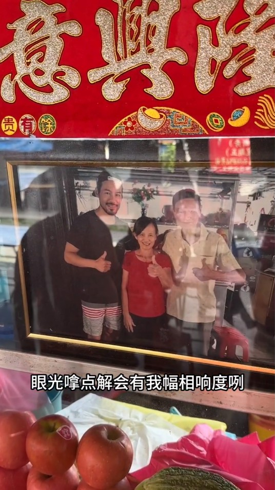 徐荣介绍亲友所开的一间果汁店，店外放有他的照片。