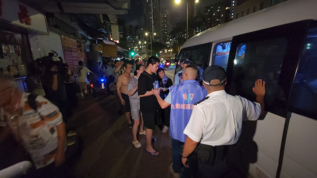 多名市民乘坐警方安排的小巴前往社區會堂。
