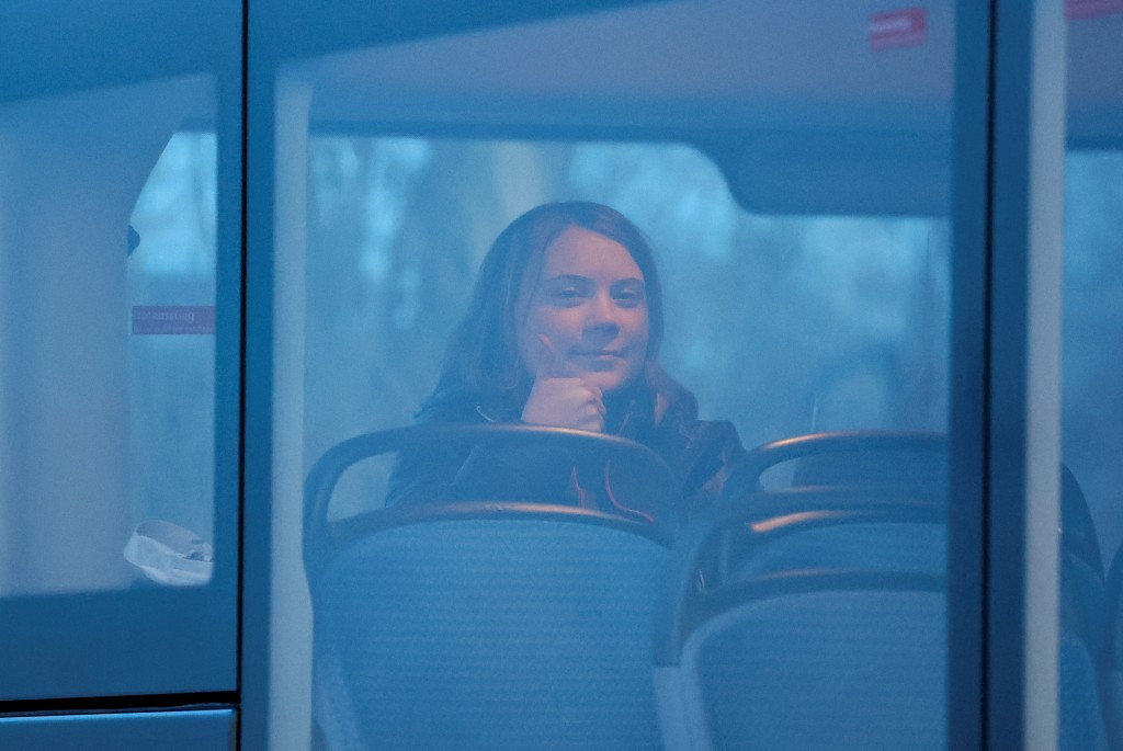 环保少女通贝里独自一人坐在一辆警察巴士上，对镜头竖起姆指。路透社
