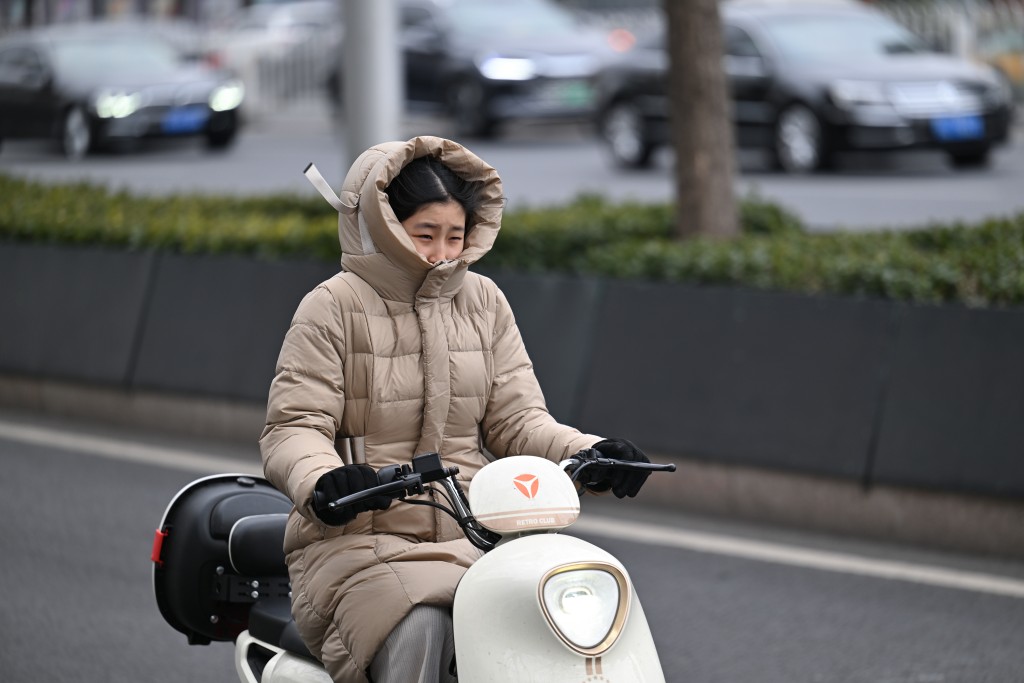 天氣嚴寒，北京市民以「全副武裝」出行。（新華社）