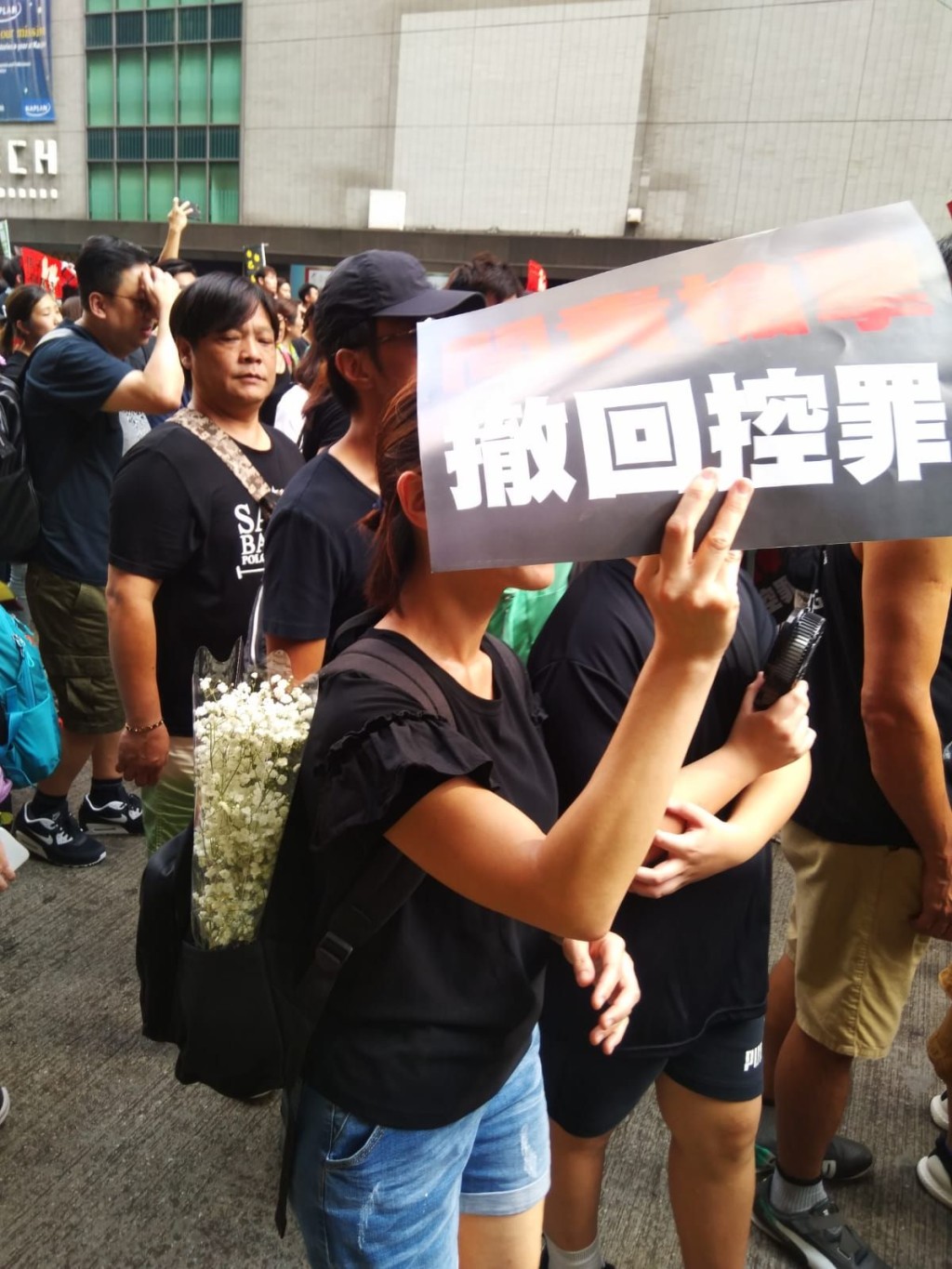 不少人亦手持鮮花、紙花或繫上白絲帶