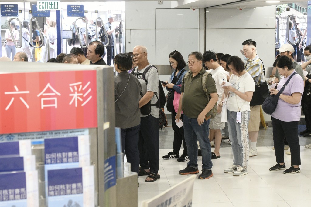 大批市民在投注站排隊購買六合彩 。資料圖片