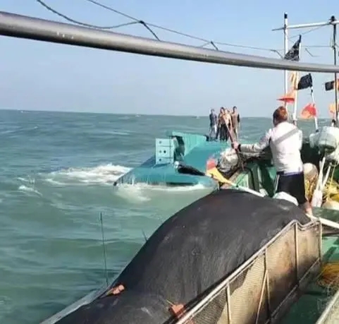 網傳視頻顯示，一船隻翻覆在海面上，船上站著數人正在等待救援。