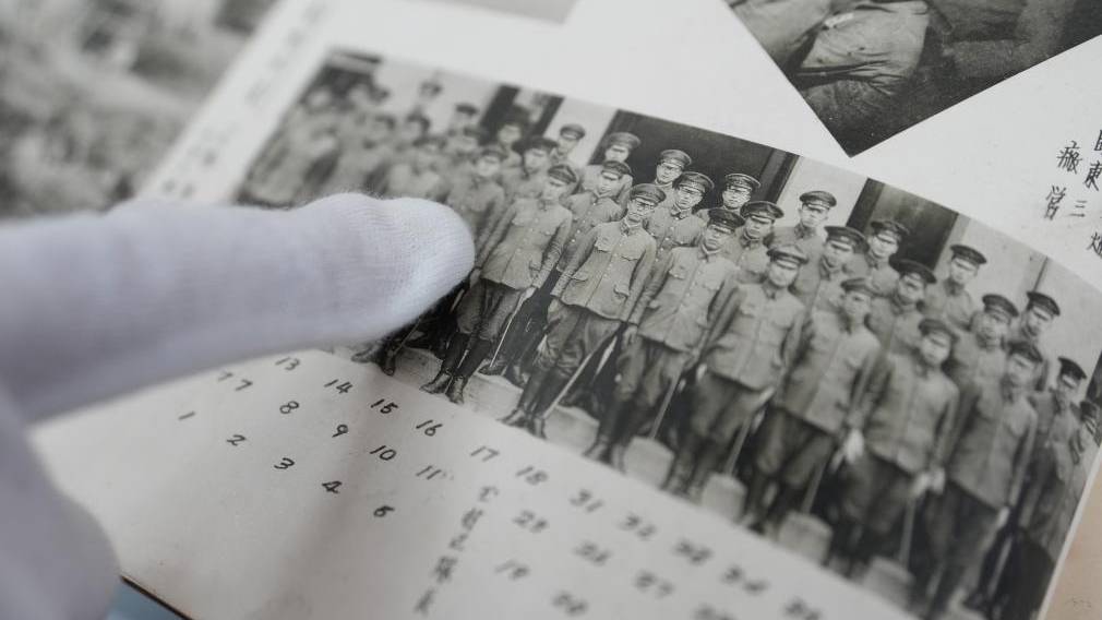工作人員展示侵華日軍相關相冊（影印件）。新華社