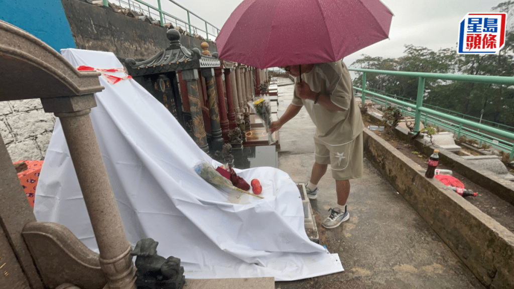 從深圳來的粉絲郝先生，冒雨向家駒墓碑獻花悼念。楊偉亨攝