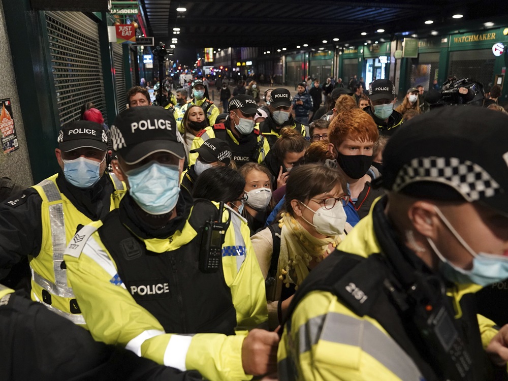 環保少女通貝里(中)到格拉斯哥後，需由警員護送離開。AP圖