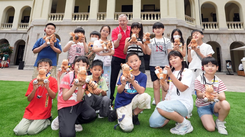 香港賽馬會行政總裁應家柏（後排右五）與其他馬會義工帶領基層家庭參與大館導賞團，參觀及介紹大館的歷史及特色。