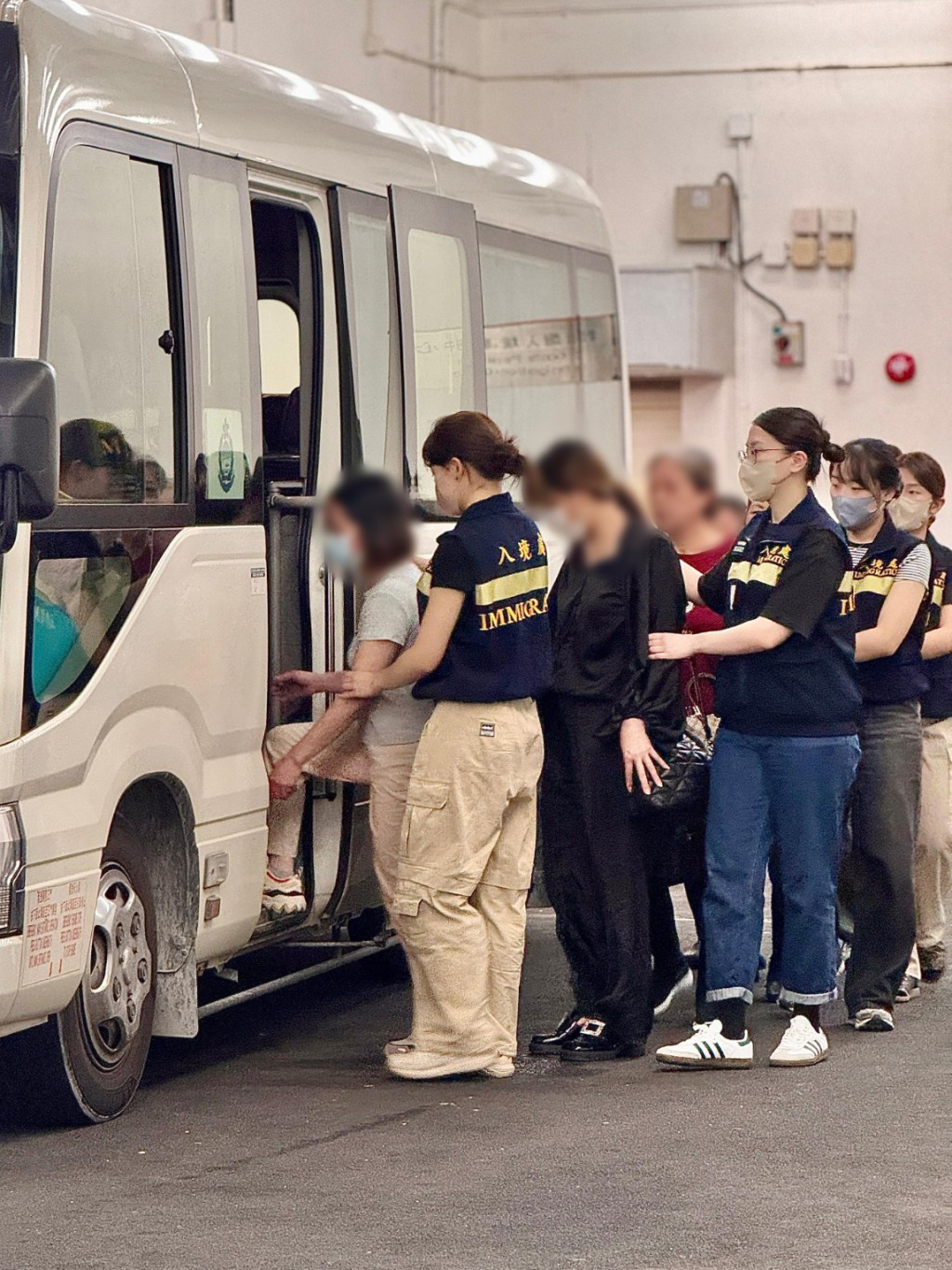 被遣返人士在入境處人員押送下離開羈押地點前往機場。入境處圖片