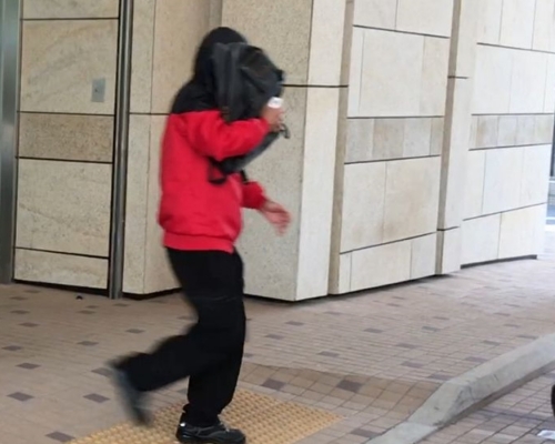 湯啟文日前離開法院時以風褸蓋頭。