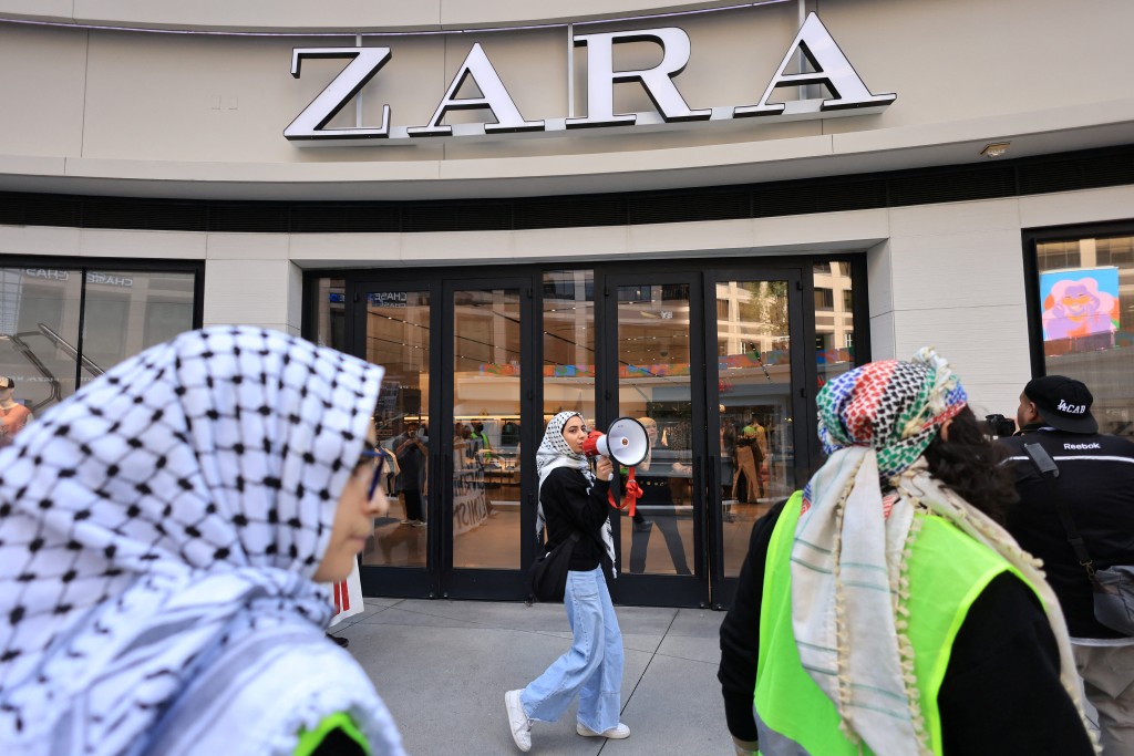 示威者经过洛杉矶市中心Zara店门外。路透社