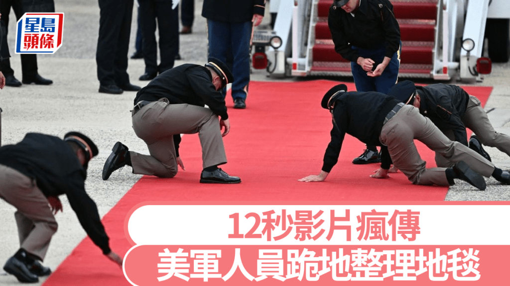 美軍人員跪地整理紅地毯。法新社