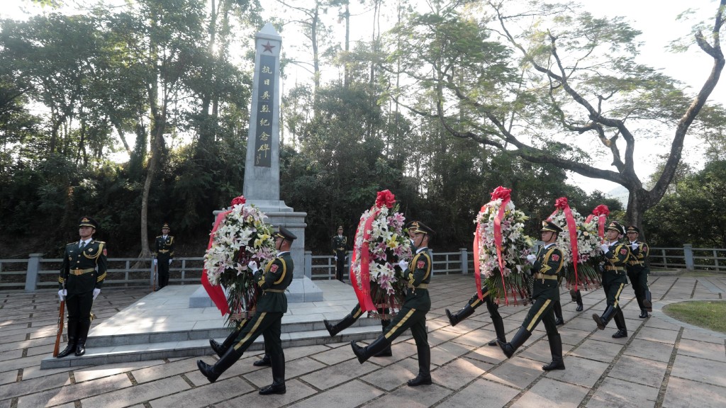 解放軍駐港部隊代表向抗日戰爭時期英勇犧牲的革命先烈敬獻花籃。政府新聞處