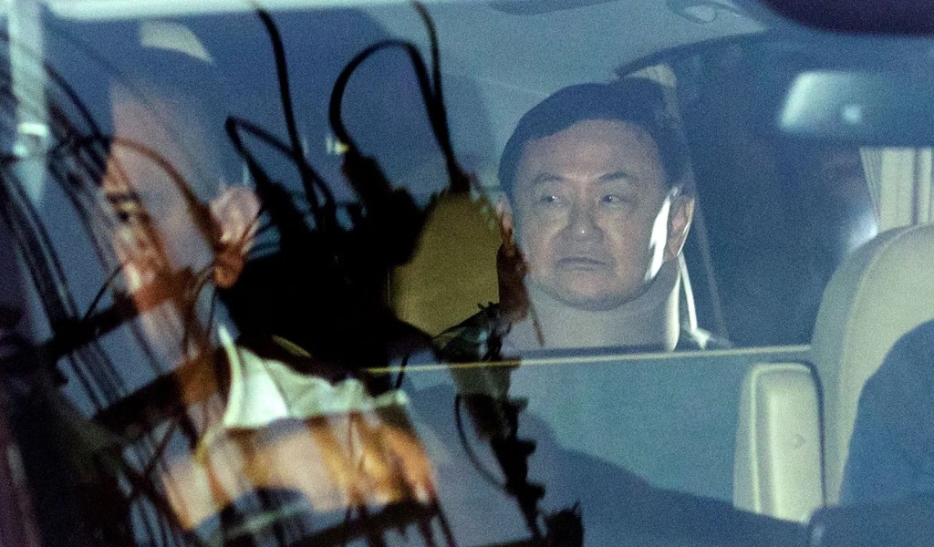 他信（右）获得假释返回曼谷住所，被外界质疑得到特殊待遇。美联社