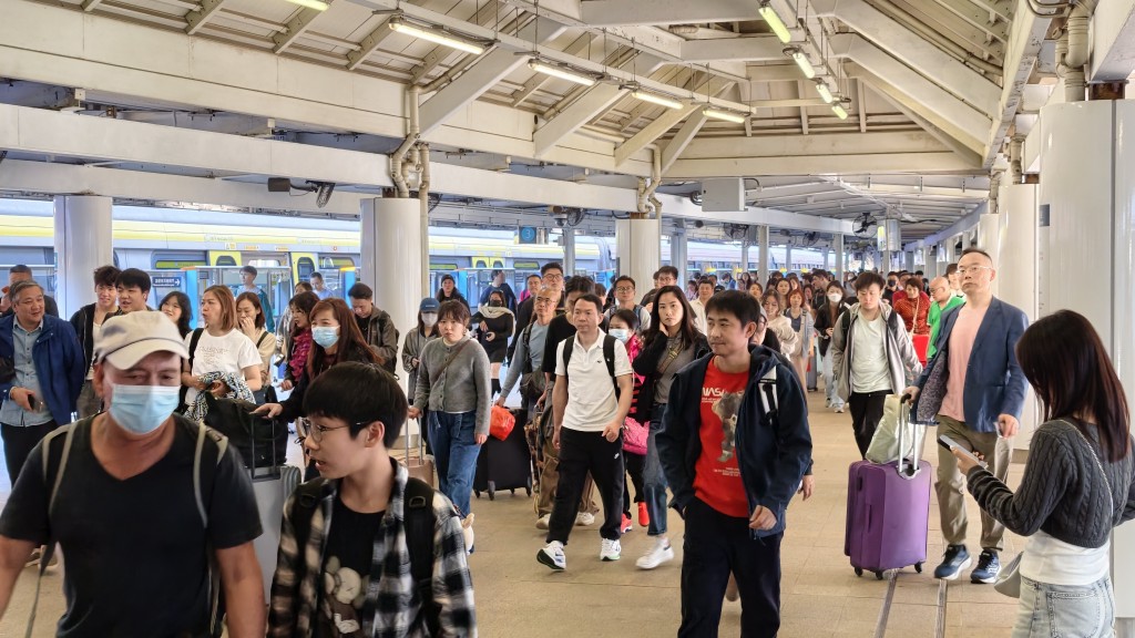 有市民帶同一家大細，拖着行李箱「一抽二褦」北上。黃文威攝