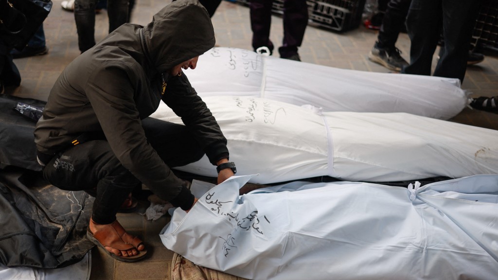 以軍空襲加沙拉法，一名男子看着遺體傷心痛哭。 路透社