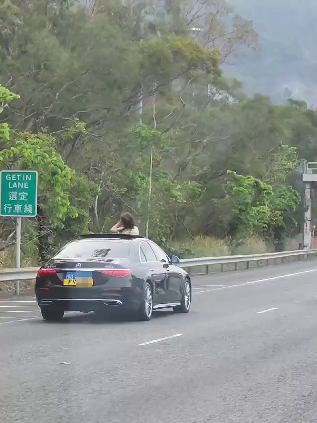 一名女乘客伸头出车，并举起手机拍摄。马路的事讨论区FB