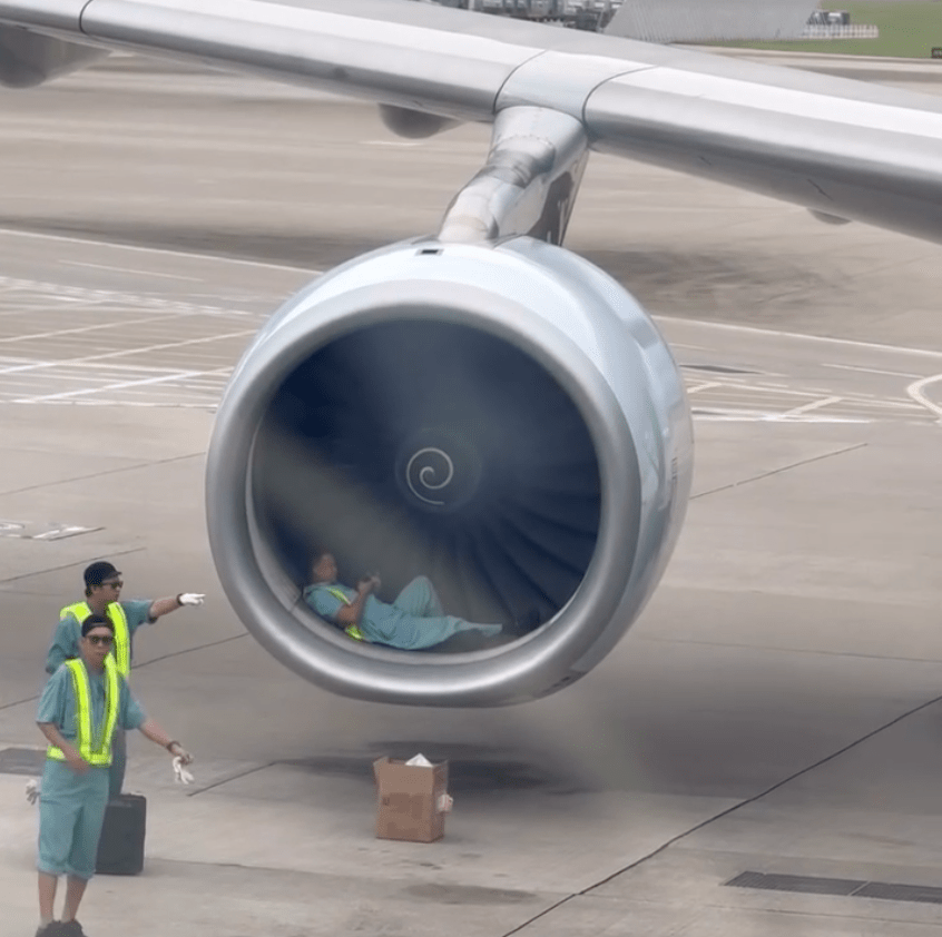 一名機場地勤維修人員躺在飛機引擎前，被指正在小休。Threads @ toto_tongpuiyee 影片截圖