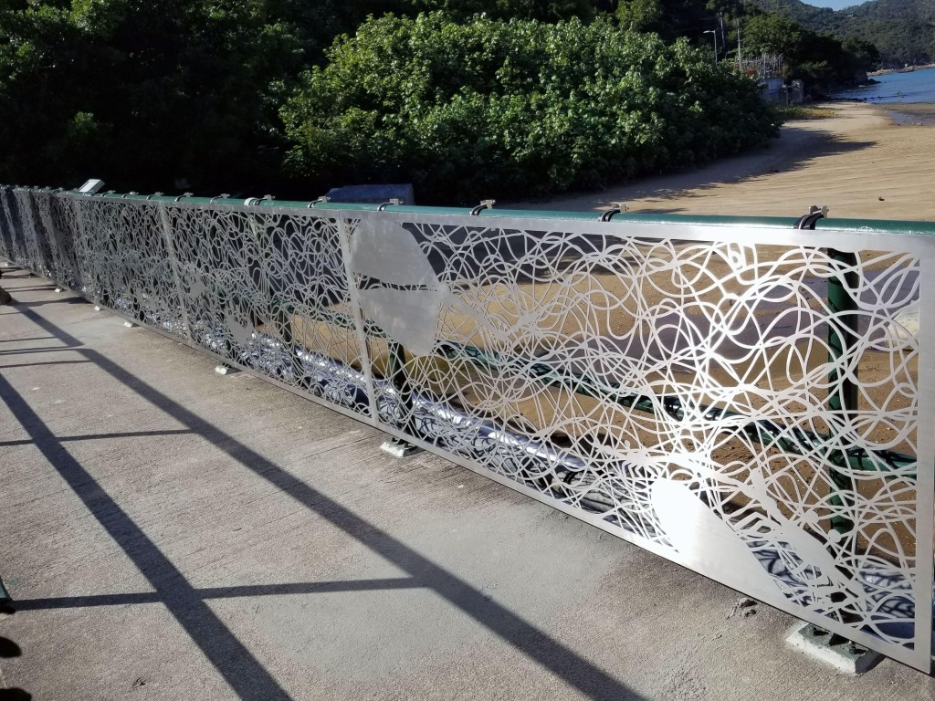 艺术家林玉莲在南丫岛河口的小桥栏杆创作镂刻造型装置，阳光穿过装置，为小桥带来变化不定的影子地画。