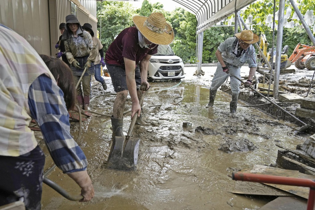 日本南部福岡縣久留米市，民眾清理暴雨引發土石流後留下的泥漿。AP
