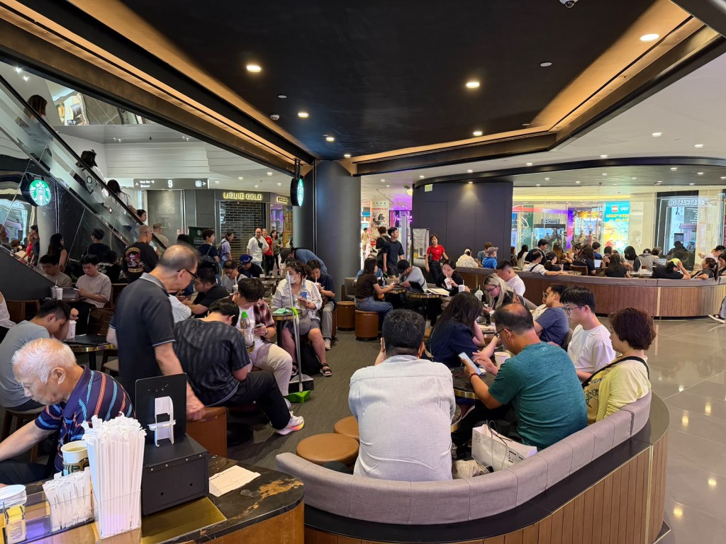 商場扶手電梯旁的連鎖咖啡店座無虛席,休憩座椅區幾乎一位難求。 商場扶手電梯旁的連鎖咖啡店座無虛席,休憩座椅區幾乎一位難求。