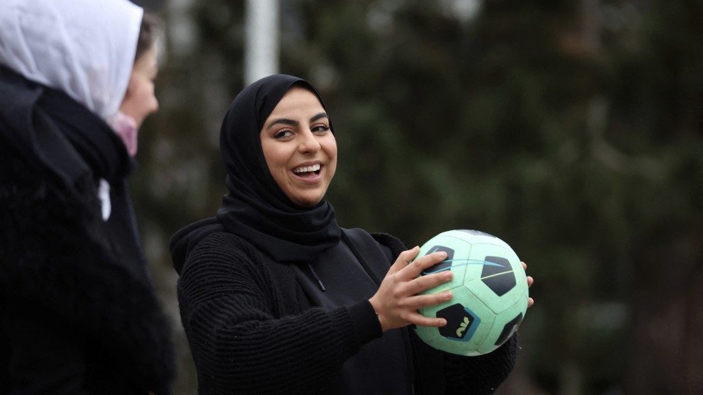 2022年2月法国参议院审理一项竞技体育禁戴头巾法案期间，有女性集会戴头巾踢足球抗议。 路透社