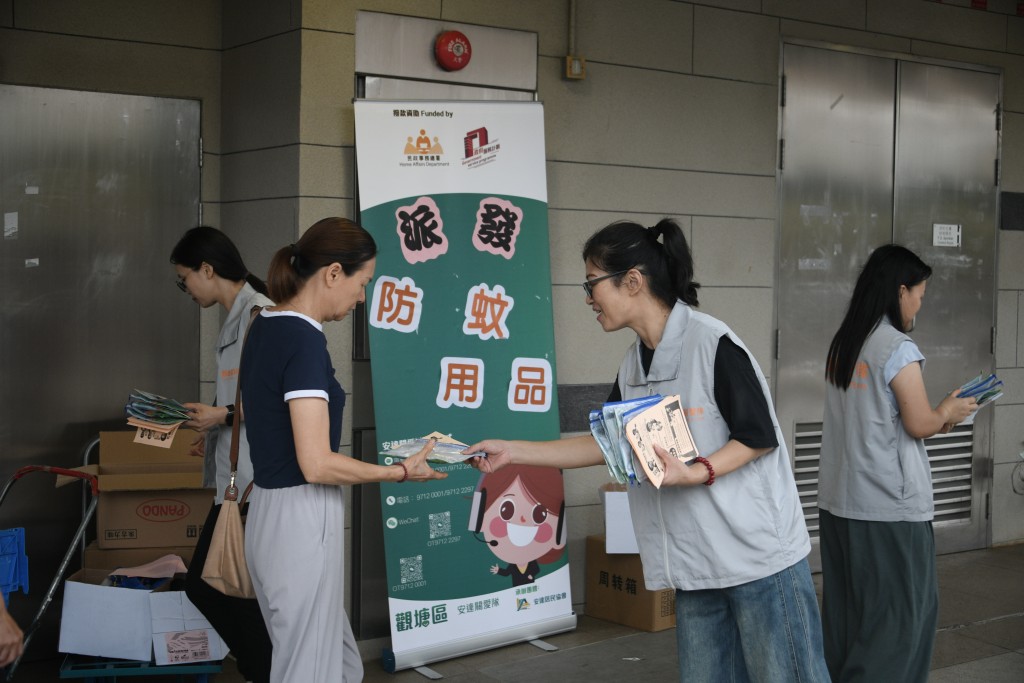 關愛隊向居民派發蚊怕水、蚊貼等滅蚊用品。陳浩元攝