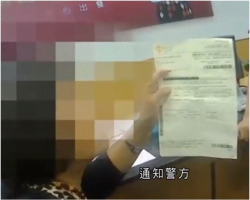 婦人手持假香港醫院繳費單到銀行匯款。 