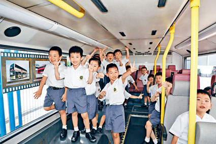 小學生急不及待登上巴士參觀，對展出的照片相當感興趣。