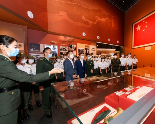 海關副關長陳子達與團員在駐港部隊官員陪同下，觀賞展板和聽取介紹。