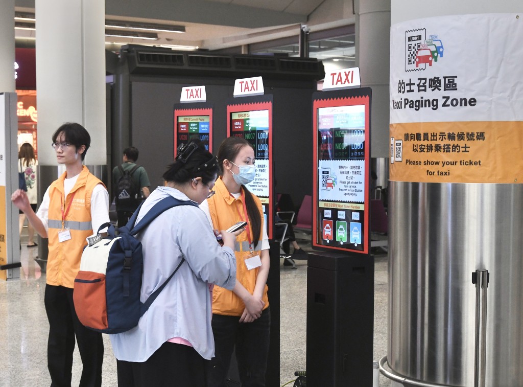 有工作人員協助旅客乘搭的士。