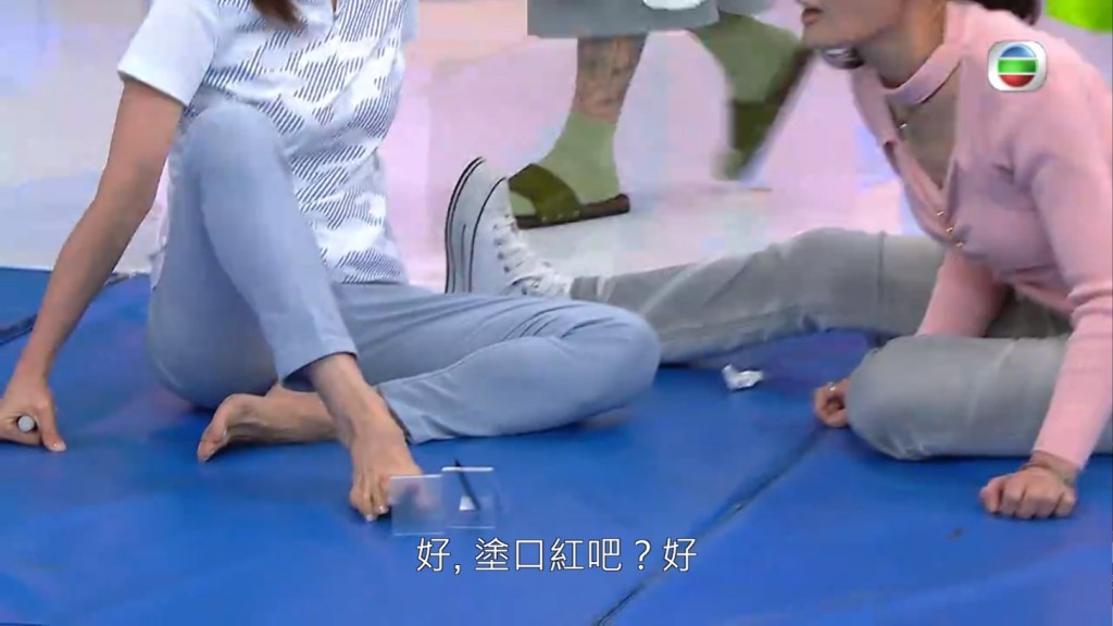 姚瑩瑩用腳同何芷姍化妝。