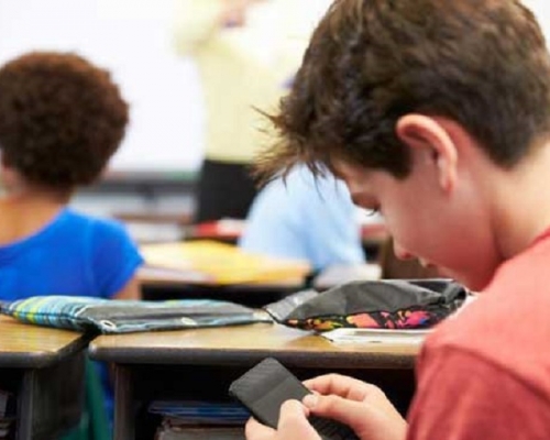 法国通过禁止初中以下学生校园内用手机，认为学生滥用手机会分散其课堂注意力。网图