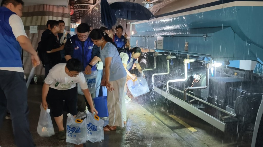 關愛隊冒雨到樓下取水備用。黃文威攝