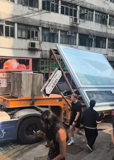 路牌被撞至成45度角。但行人依然無懼在旁路過。fb 車cam L（香港群組）SH Hong影片截圖  