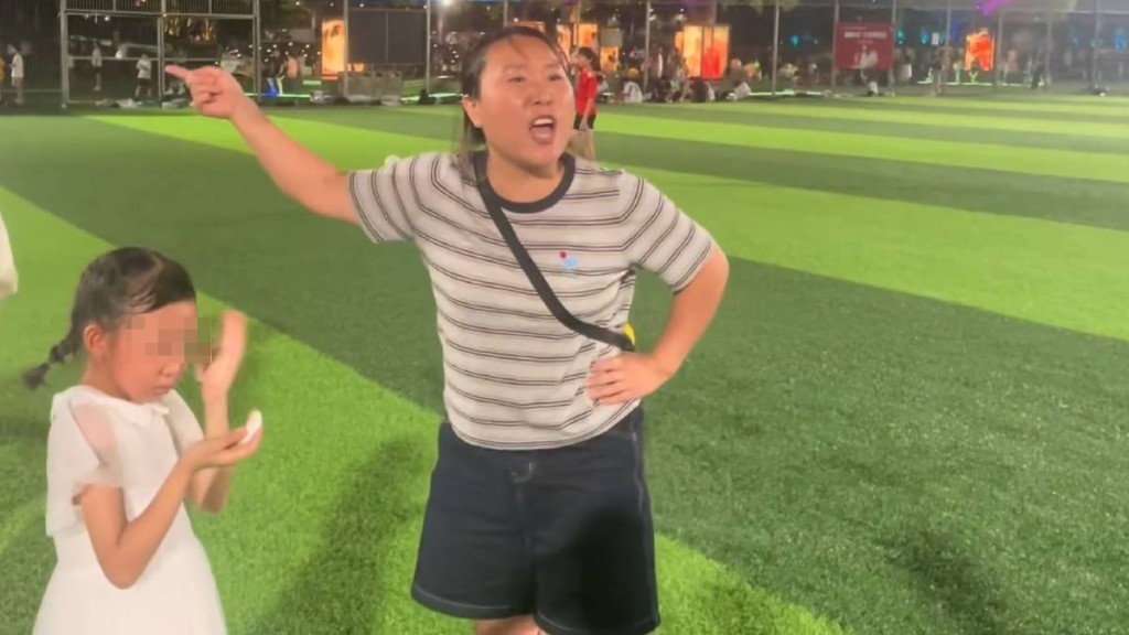 大妈不顾危险带孩子穿越足球场，女儿被球踢中即情绪失控拒绝离开。
