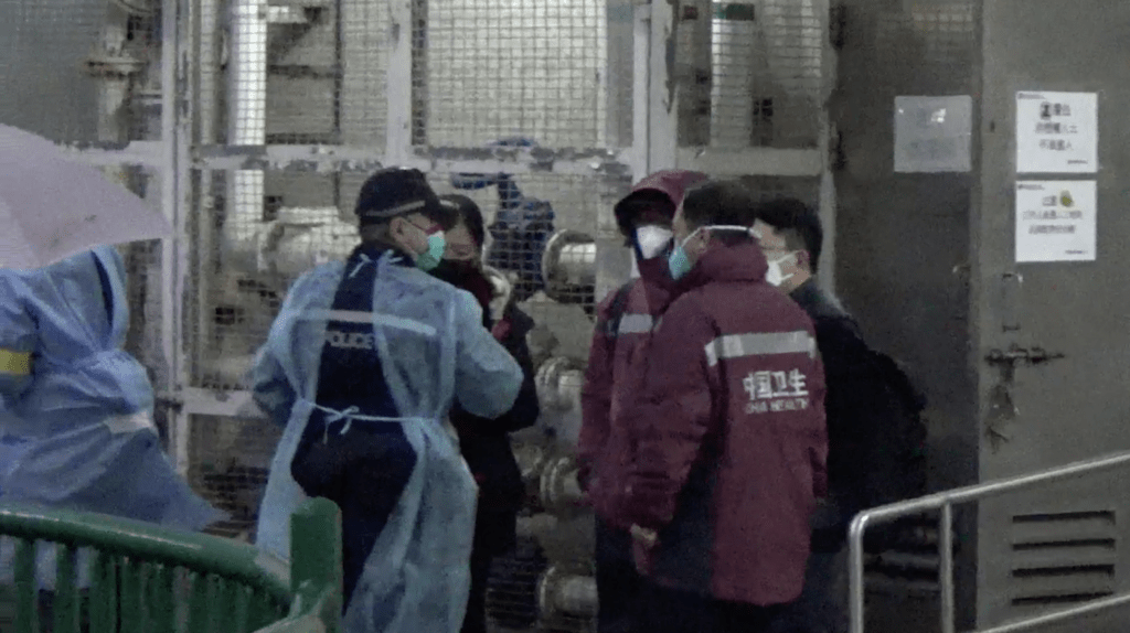4人穿著中國衞生制服專家，到博康邨地下水泵房視察，並拍攝環境相。