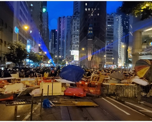 示威者堵路並射激光。