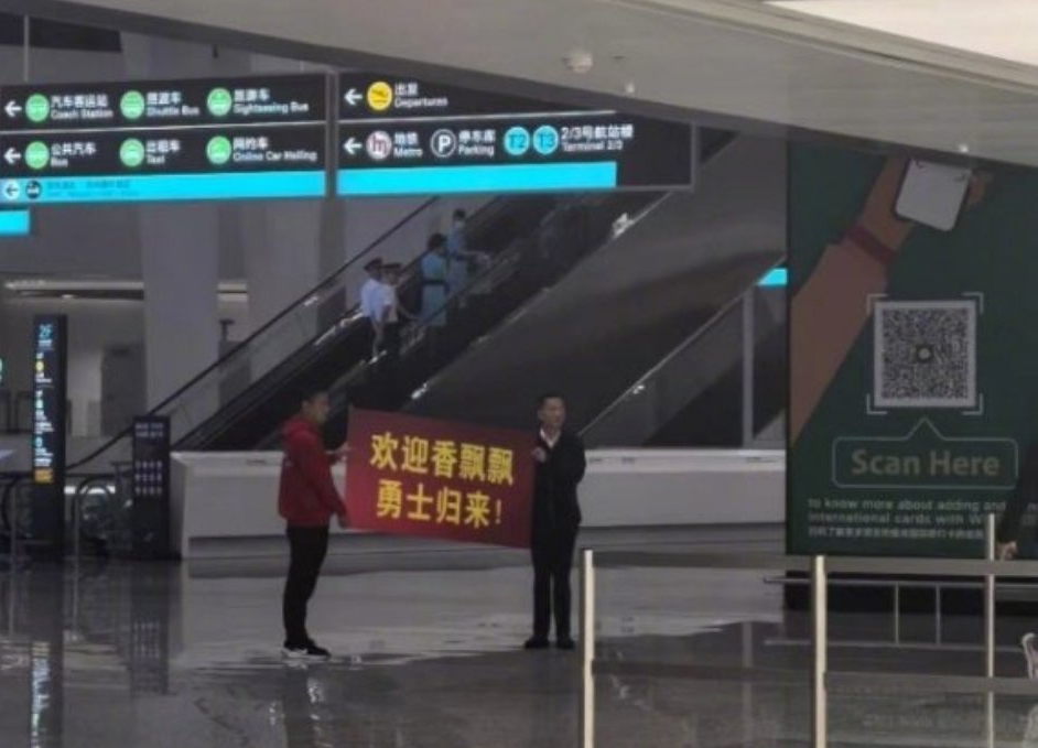 香飘飘董事长蒋建琪，在机场举牌迎接赴日回国员工的照片。