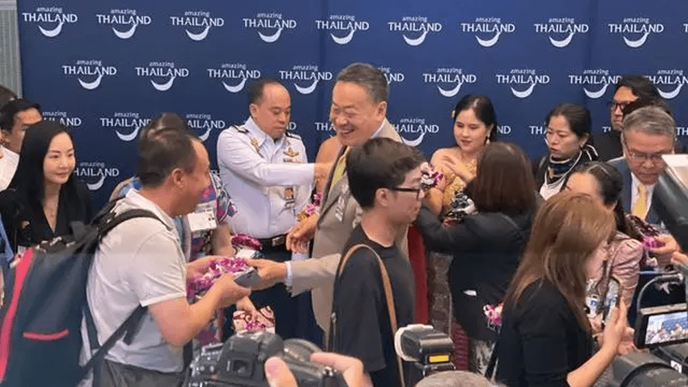 泰國總理迎接首批免簽中國遊客入境，與他們握手致意。央視截圖