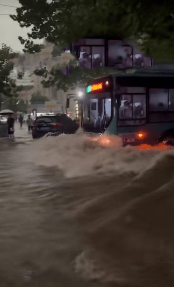 鄭州暴雨，路面積水淹沒車輪，巴士如在河上行駛。
