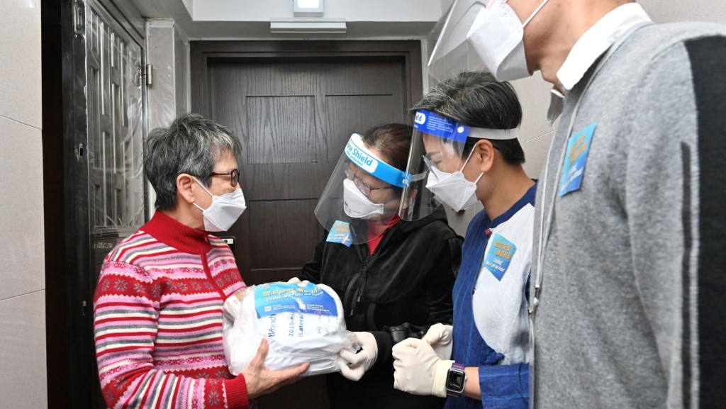 鄭若驊（右三）派發防疫服務包給一位獨居長者。政府新聞處圖片