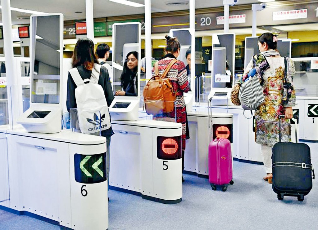 日本旅客在成田機場用人臉識別自動門入境。