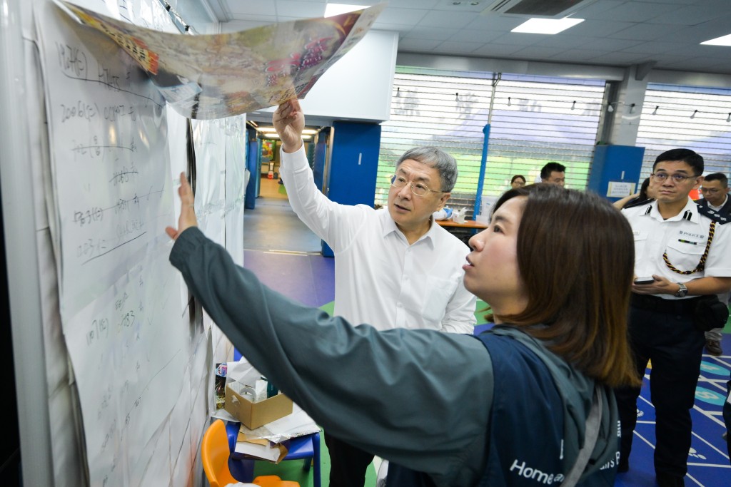 政務司副司長卓永興（左一）聽取民政總署副署長王婉蓉（左二）講述安排預約車輛的工作。