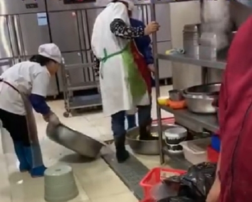 武漢東湖學院食堂工作人員被揭發用腳洗菜。影片截圖