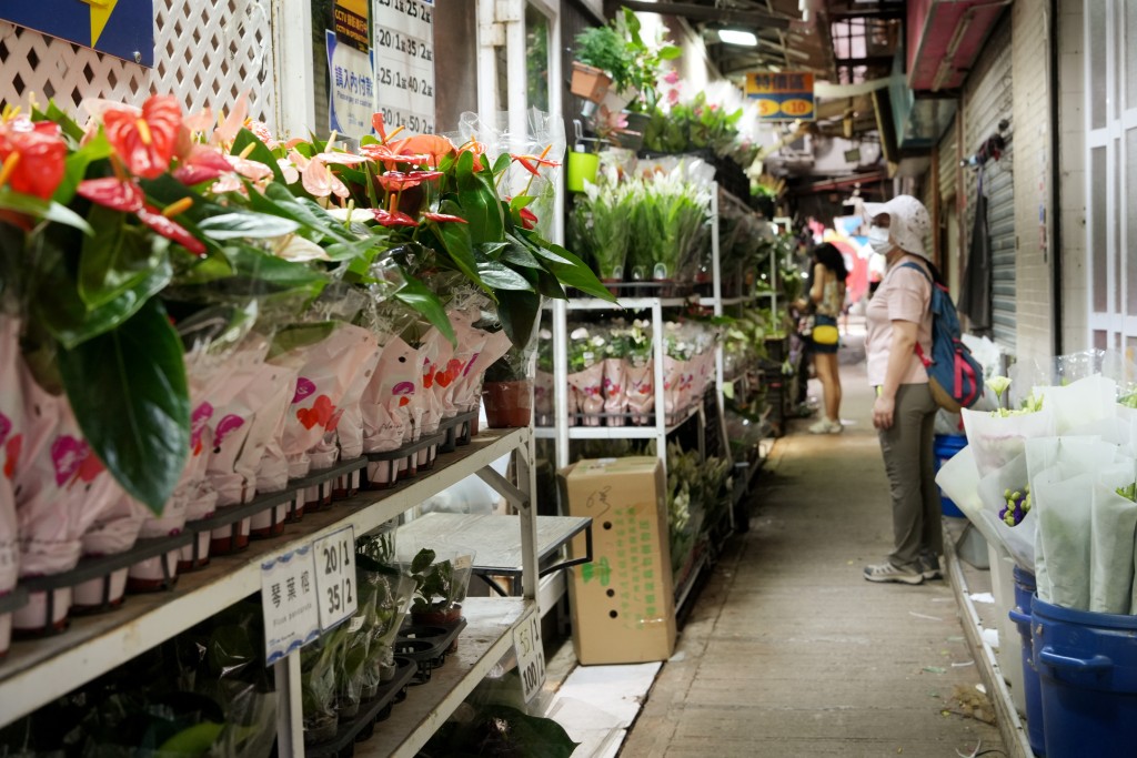 有花店將裝滿盆栽的雙層鐵架，放置行人路上。吳艷玲攝